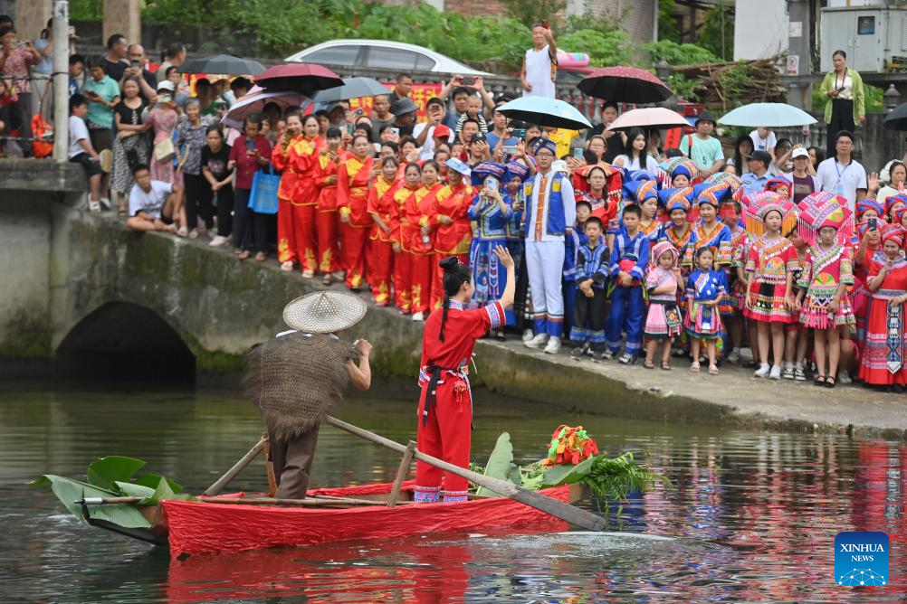 Orang ramai menonton persembahan luar di Perbandaran Wangdong di Kaunti Autonomi Rongshui Miao di Wilayah Autonomi Guangxi Zhuang, selatan China, 18 Ogos 2024. Sejak beberapa tahun mutakhir, Perbandaran Wangdong telah memanfaatkan sumber airnya yang banyak untuk menggalakkan daya hidup luar bandar. Disokong oleh "bantuan berpasangan" dari Bandar Lianjiang di Provinsi Guangdong, perbandaran itu berjaya menganjurkan pertandingan sukan air, nyanyian duet lagu gunung dan aktiviti bertemakan warisan budaya tidak ketara di sekolah. Inisiatif ini bertujuan untuk membina jenama "budaya air" dan memajukan pembangunan pelancongan budaya etnik. (Xinhua/Huang Xiaobang)
