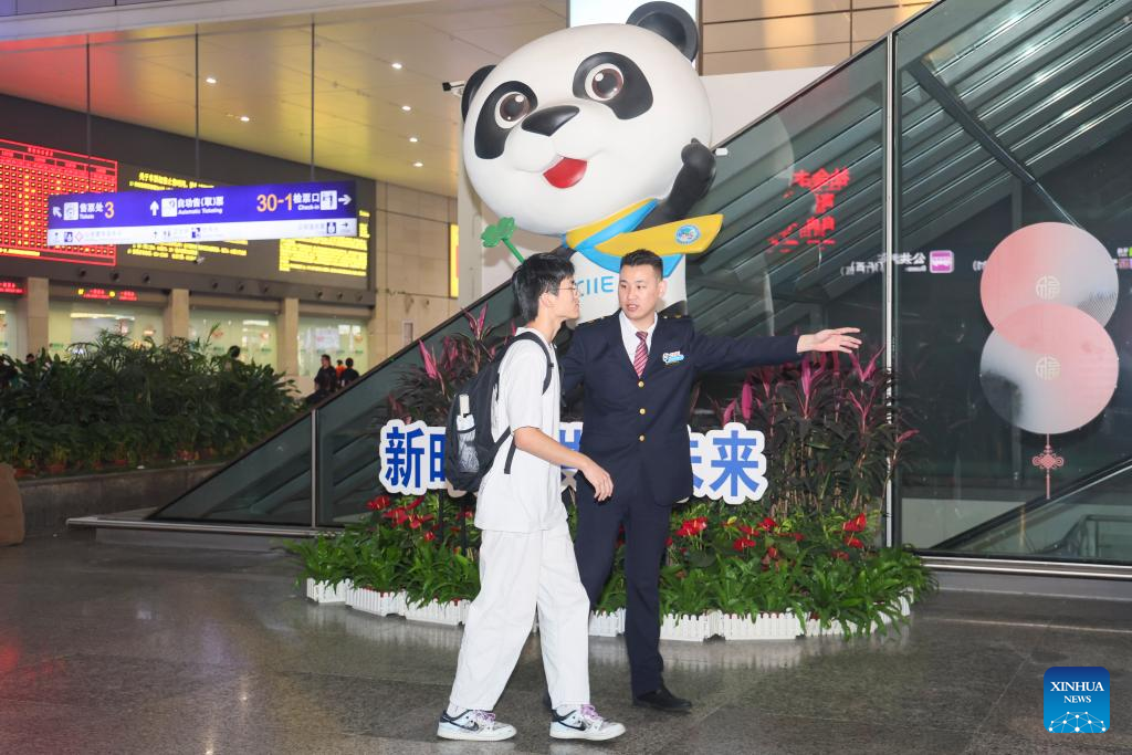Seorang petugas menunjukkan jalan kepada penumpang di Stesen Kereta Api Hongqiao Shanghai di timur China pada 3 November 2024. Menjelang Ekspo Import Antarabangsa China (CIIE) ketujuh, Stesen Kereta Api Hongqiao Shanghai menyediakan ruang perkhidmatan untuk ekspo itu yang antaranya meliputi perkhidmatan seperti tiket, dan daftar masuk bagasi.Stesen itu turut menyediakan bas ulang-alik percuma dari dan ke Pusat Konvensyen dan Pameran Kebangsaan (Shanghai) untuk peserta serta petugas rasmi CIIE. (Xinhua/Wang Xiang)