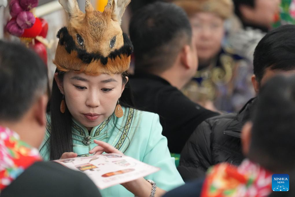 Liu Jinxin, pewaris teknik sulaman sedang berinteraksi dengan penumpang. (Xinhua/Wang Song)