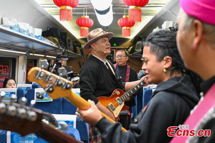 Penghibur membuat persembahan sempena Tahun Baharu Cina yang menjelang tiba, dalam kereta api rentas sempadan D87 China-Laos, 14 Januari 2025. (China News Service/Li Jiaxian)