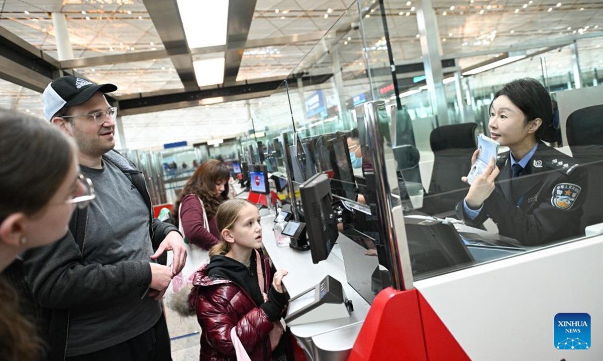 Pegawai imigresen, Chen Miao (pertama dari kanan) sedang mengendalikan prosedur pengecualian visa transit bagi pelancong dari Amerika Syarikat di Lapangan Terbang Antarabangsa Capital Beijing pada 28 Januari 2025. (Foto/Xinhua)