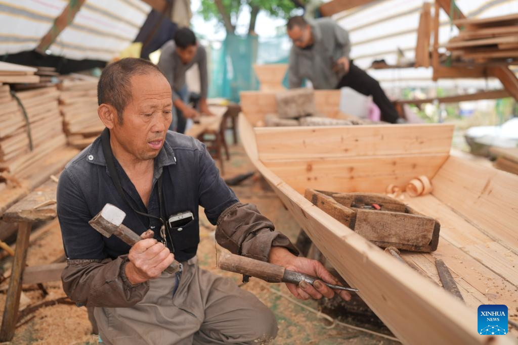 Qian Shoutan sedang membuat bot kajang hitam bersama-sama dengan perantisnya di Shaoxing, Provinsi Zhejiang, di timur China pada 12 Jun 2025. (Xinhua/Weng Xinyang)